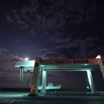 ライトアップされたクレーン式上架施設と上空を通過するISS（国際宇宙ステーション）
